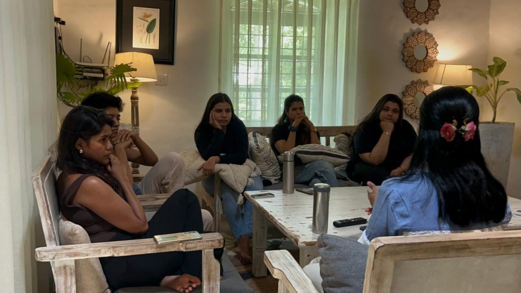 Women participating in a guided emotional wellness retreat discussion, reflecting on personal growth, healing, and self-discovery in a supportive group setting.