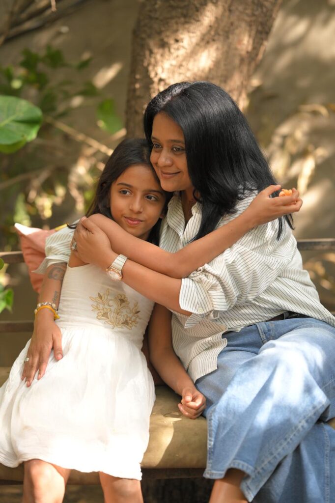 Rasesha Rabari sitting with a young girl teaching emotional wellness coaching