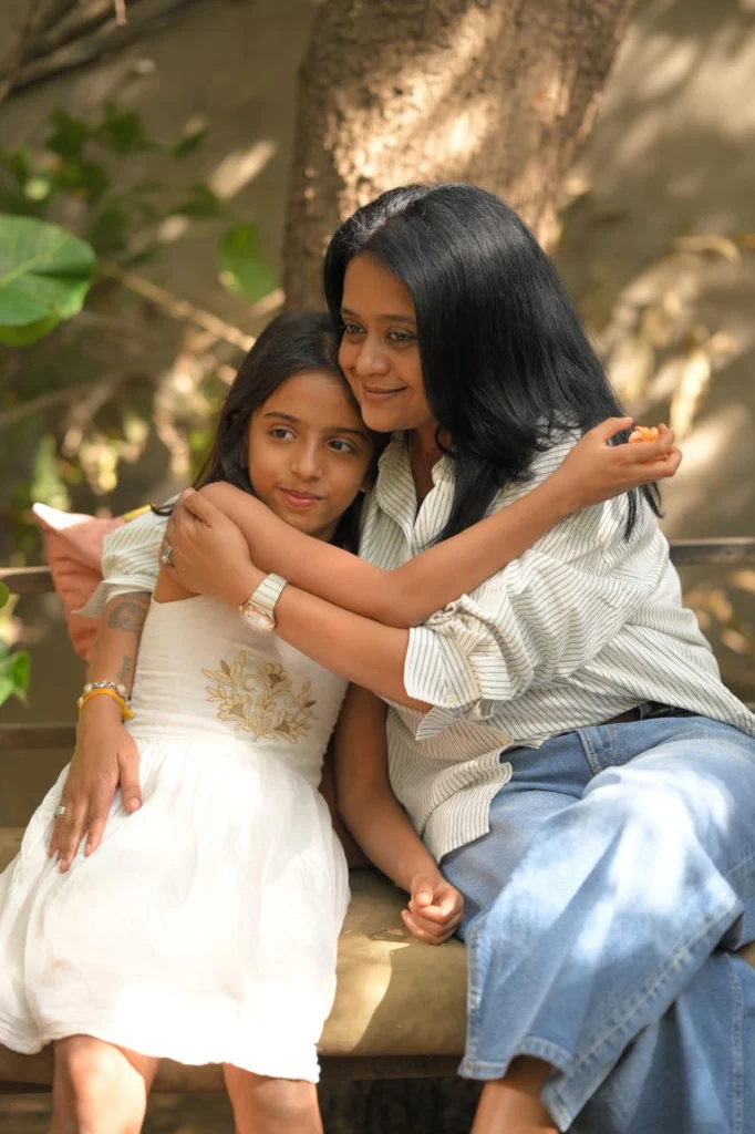 Rasesha Rabari sitting with a young girl teaching emotional wellness coaching
