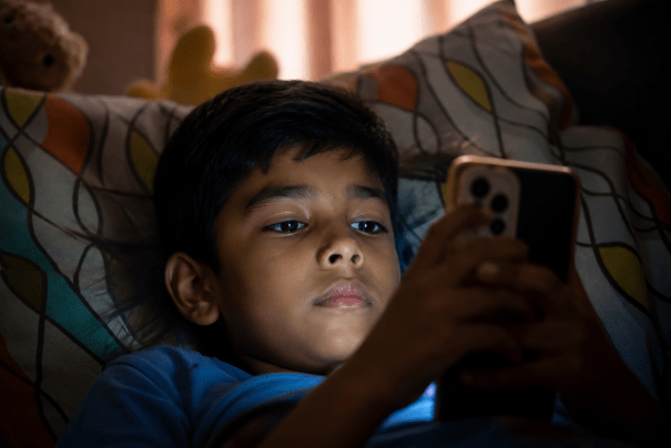 Child using a smartphone at night, illustrating how excessive screen time and constant digital stimulation can affect attention, focus, and concentration in children.